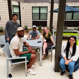 a group of people around a table smiling a group of people around a table smiling